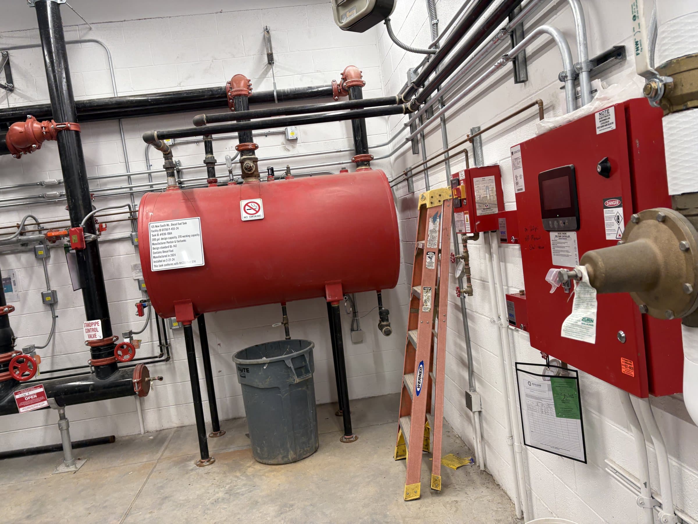Diesel fuel tank and piping in an industrial equipment room.