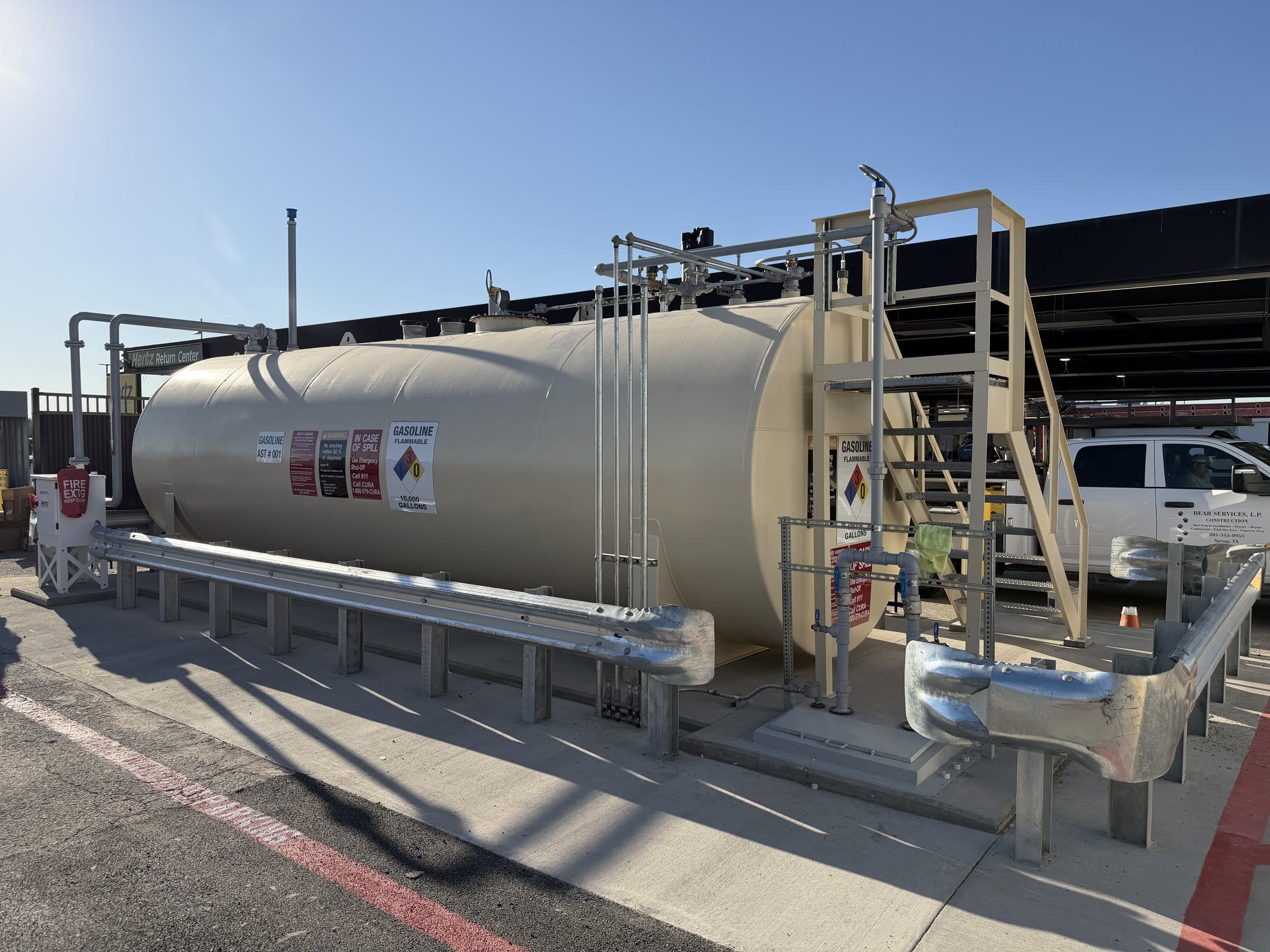 Aboveground fuel tank with stairs, guardrails and piping.